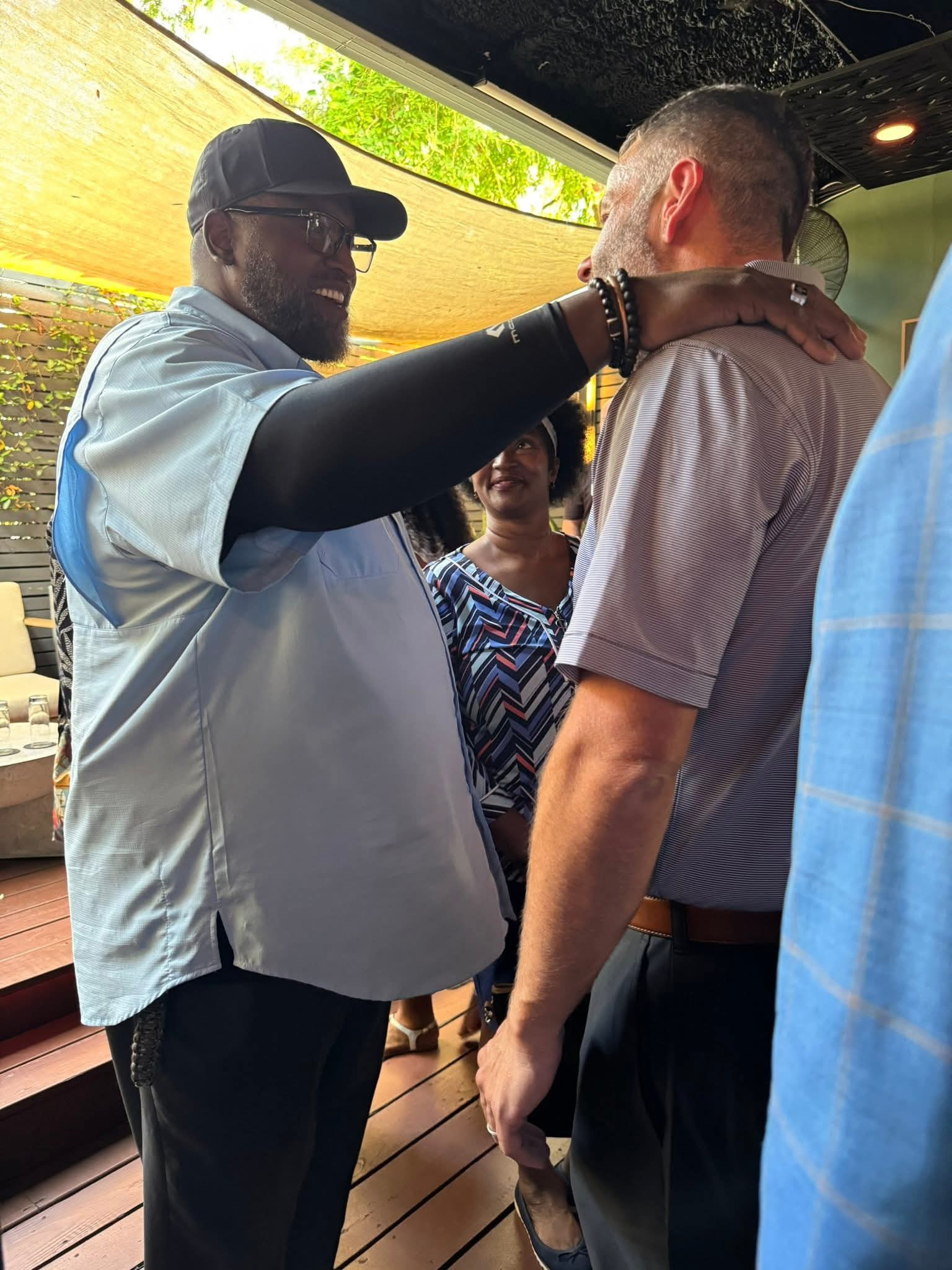 Raymond Harris praying with a community member